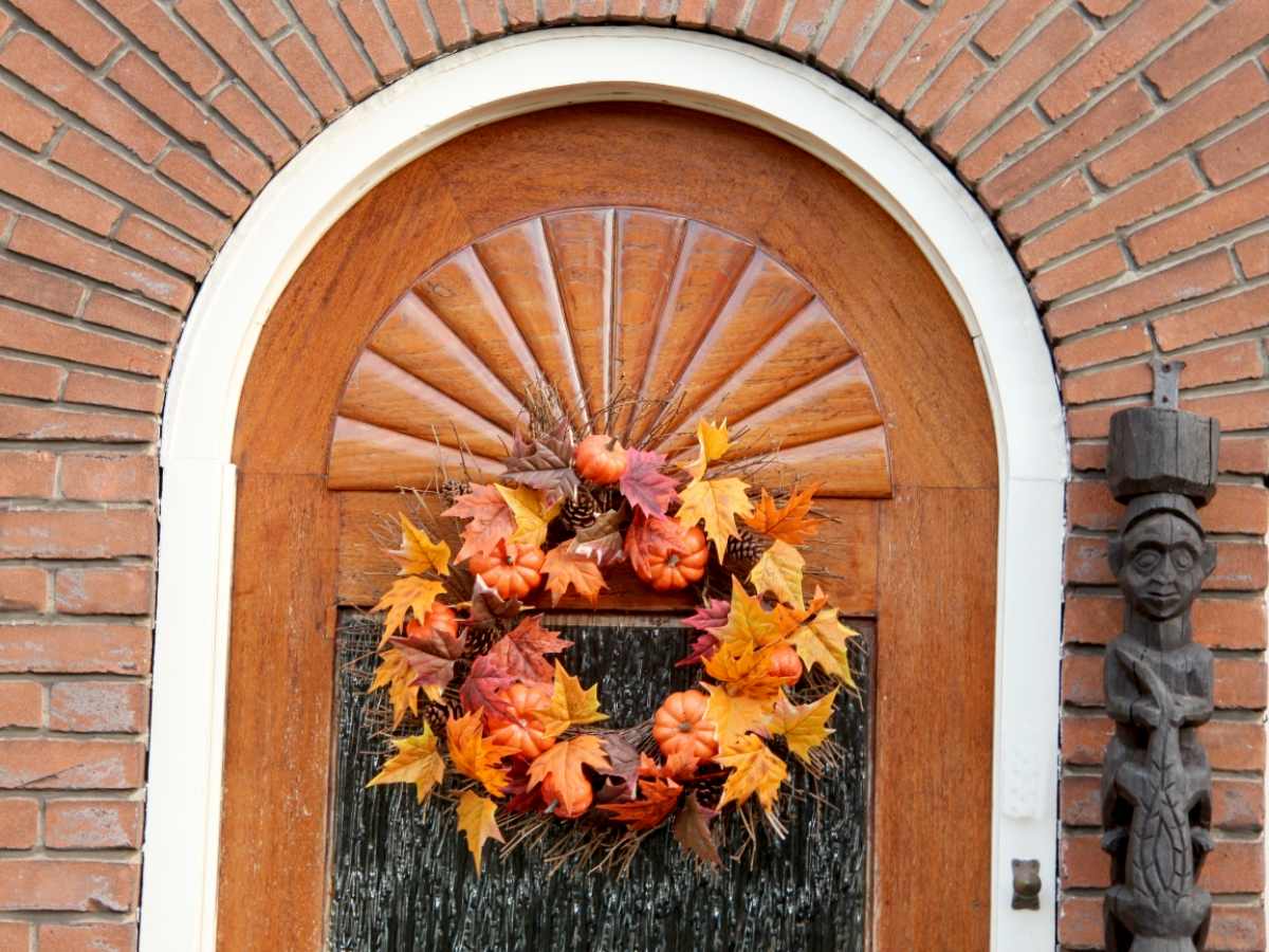 An autumnal wreath adorns a classic wooden door in the sixth photo welcoming guests with a festive blend of fall colors and harvest motifs perfectly capturing the spirit of Thanksgiving before one even steps inside