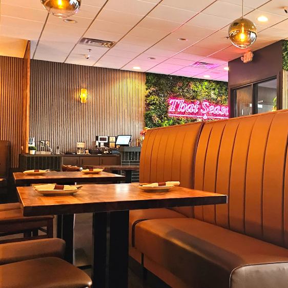 This image features a vibrant dining area with tall, caramel-colored booths lining the space, offering a comfortable and semi-private dining experience.
